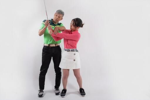 室内で女性がコーチからスイング動作の指導を受ける様子（イメージ）